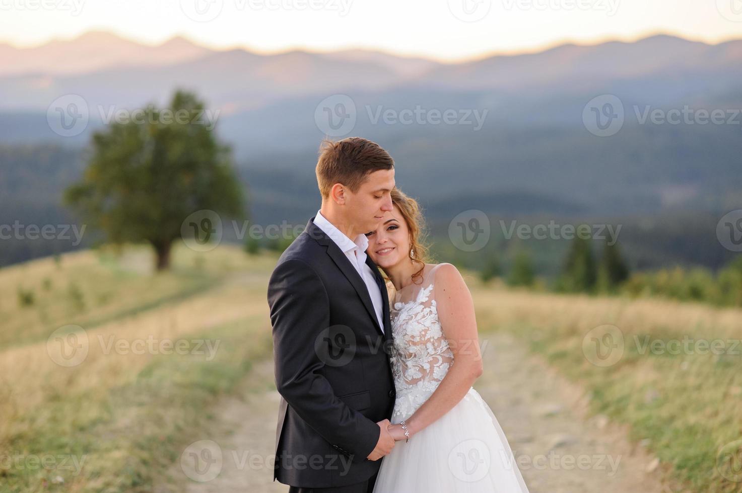 Hochzeitsfotografie in den Bergen. Braut und Bräutigam umarmen sich fest. foto