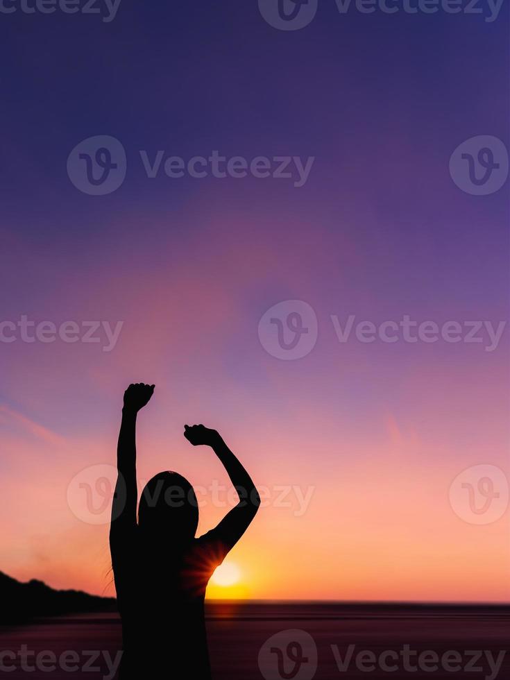 Silhouette der jungen Frau bei Sonnenaufgang auf Meereshintergrund. foto