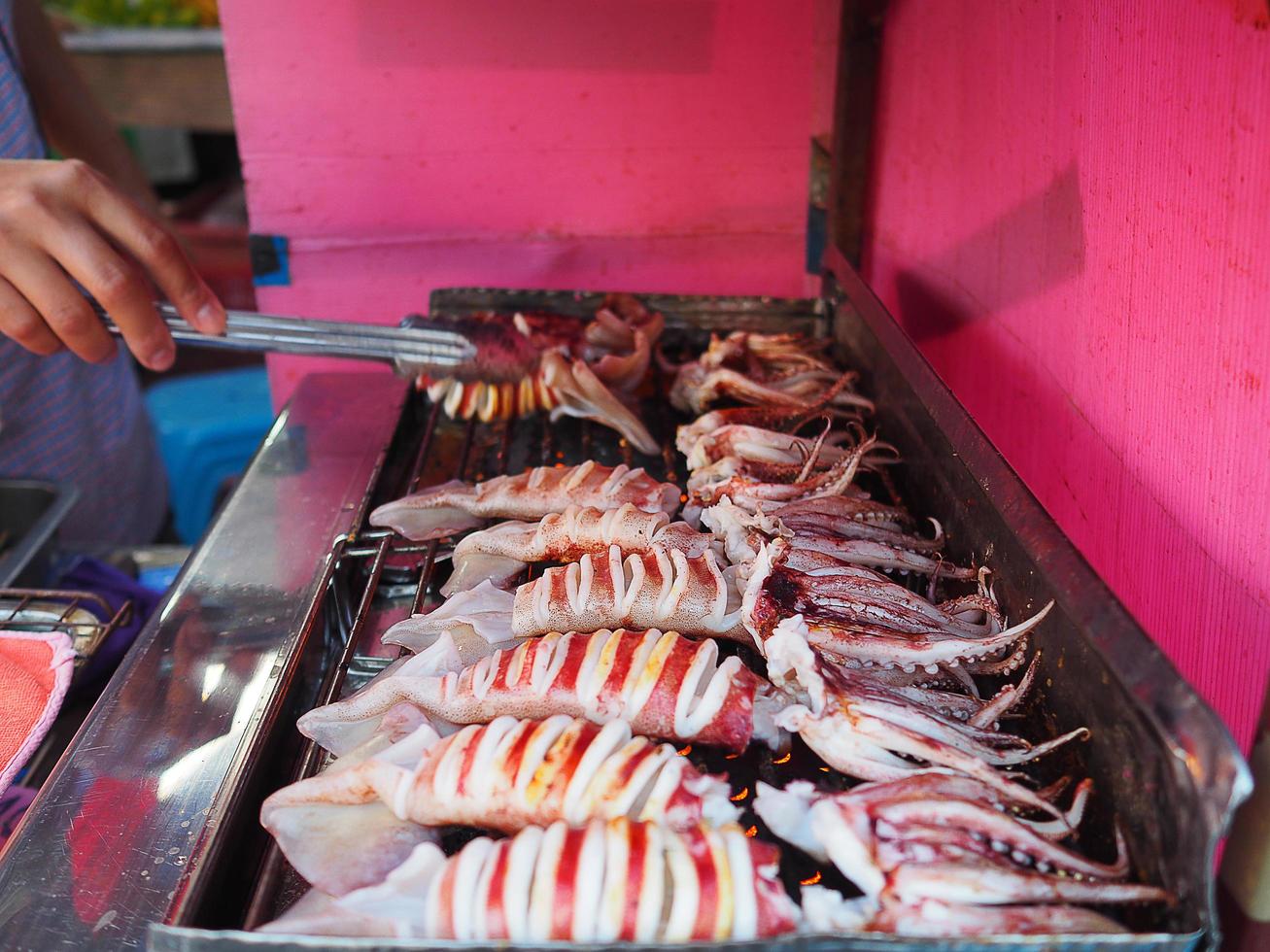 Grillen von Tintenfischen zum Verkauf auf dem Markt foto