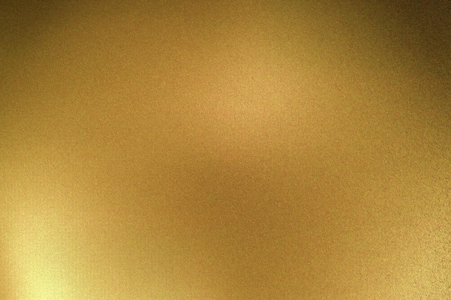 Licht auf goldener Metallplatte im dunklen Raum, abstrakter Texturhintergrund foto