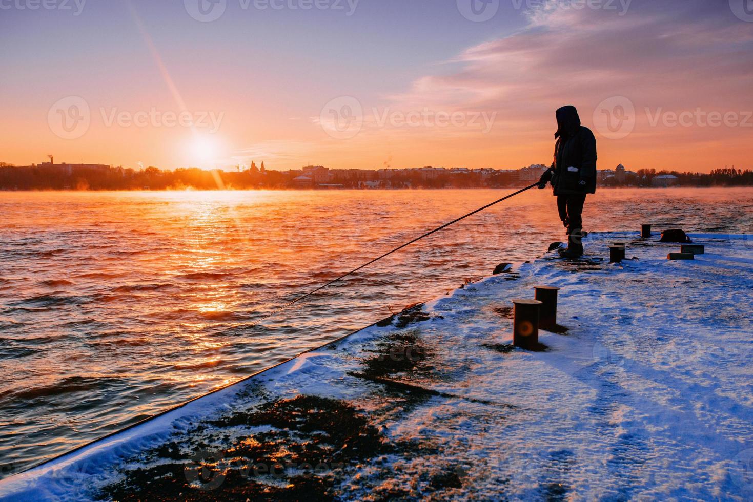 Leute auf dem Pier, die den Sonnenuntergang beobachten foto