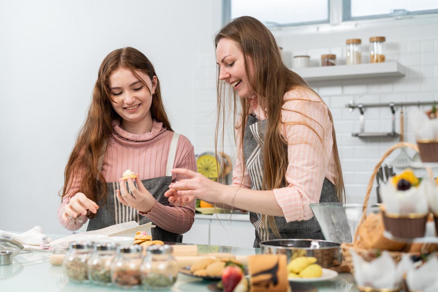 mutter und tochter backen gerne gemeinsam in der küche zu hause hausgemachte kekse. kleines Mädchen, das mit Mama Backaktivitäten lernt. schöne familienzeit am wochenende foto