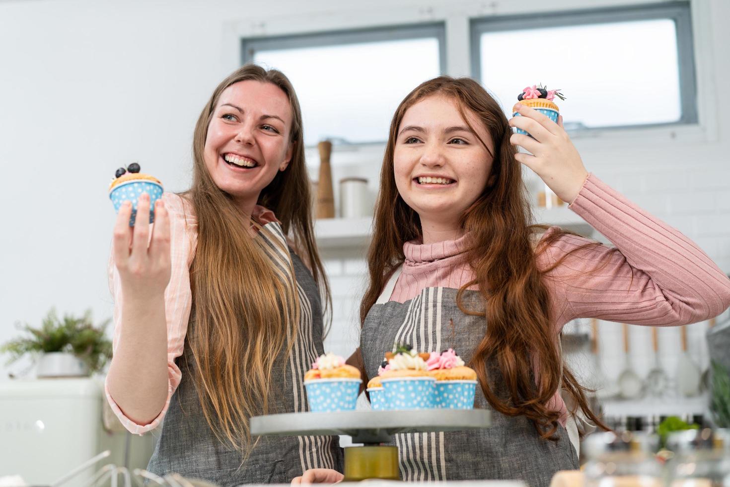 glückliche mutter und tochter zeigen stolz hausgemachten kuchen. Familienzeit genießen Sie am Wochenende das gemeinsame Backen in der Küche foto