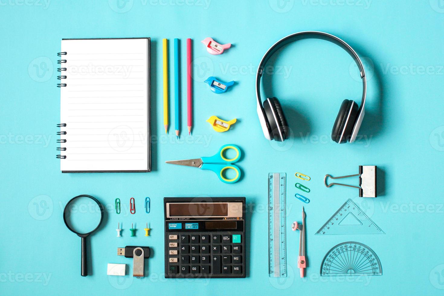flache Schreibwaren für den Schulanfang mit mathematischen Werkzeugen auf blauem Hintergrund foto