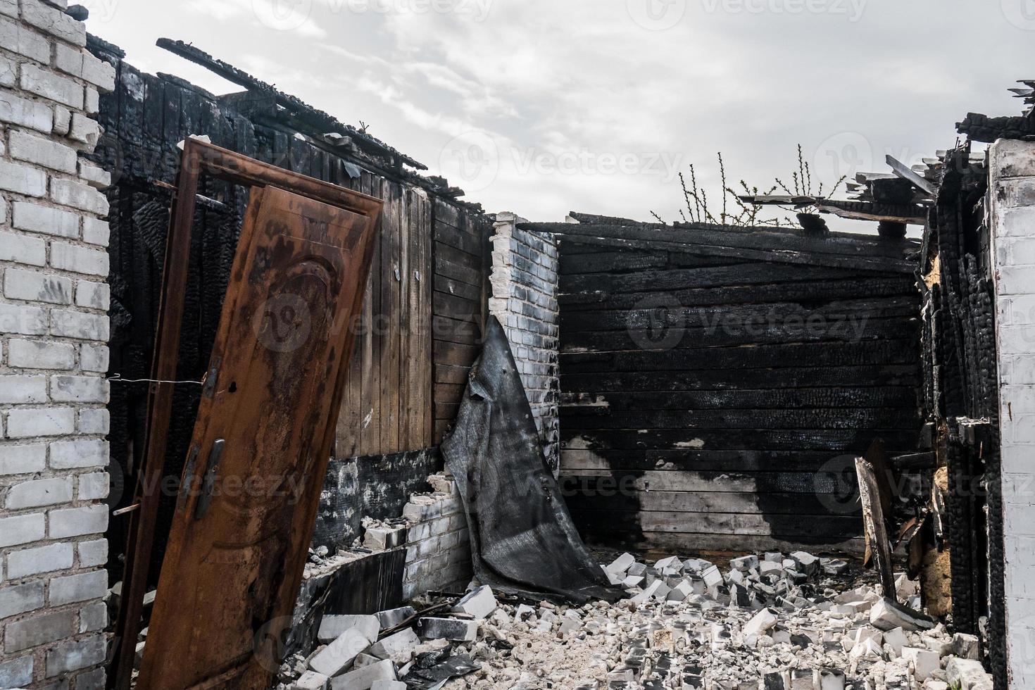 ausgebrannte Behausung mit verkohlten Wänden und Zerstörung foto
