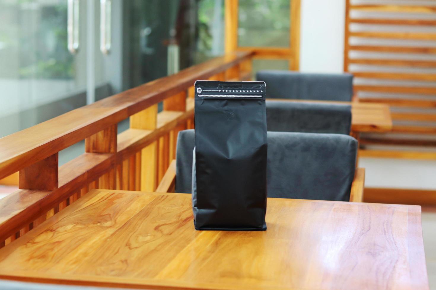 Foto einer Kaffeeverpackung, die Beutelgröße 1 kg auf dem Cafétisch steht. geeignet für Mock-up-Etikettenaufkleber, Verpackungsaufkleber für Kaffeevarianten usw.
