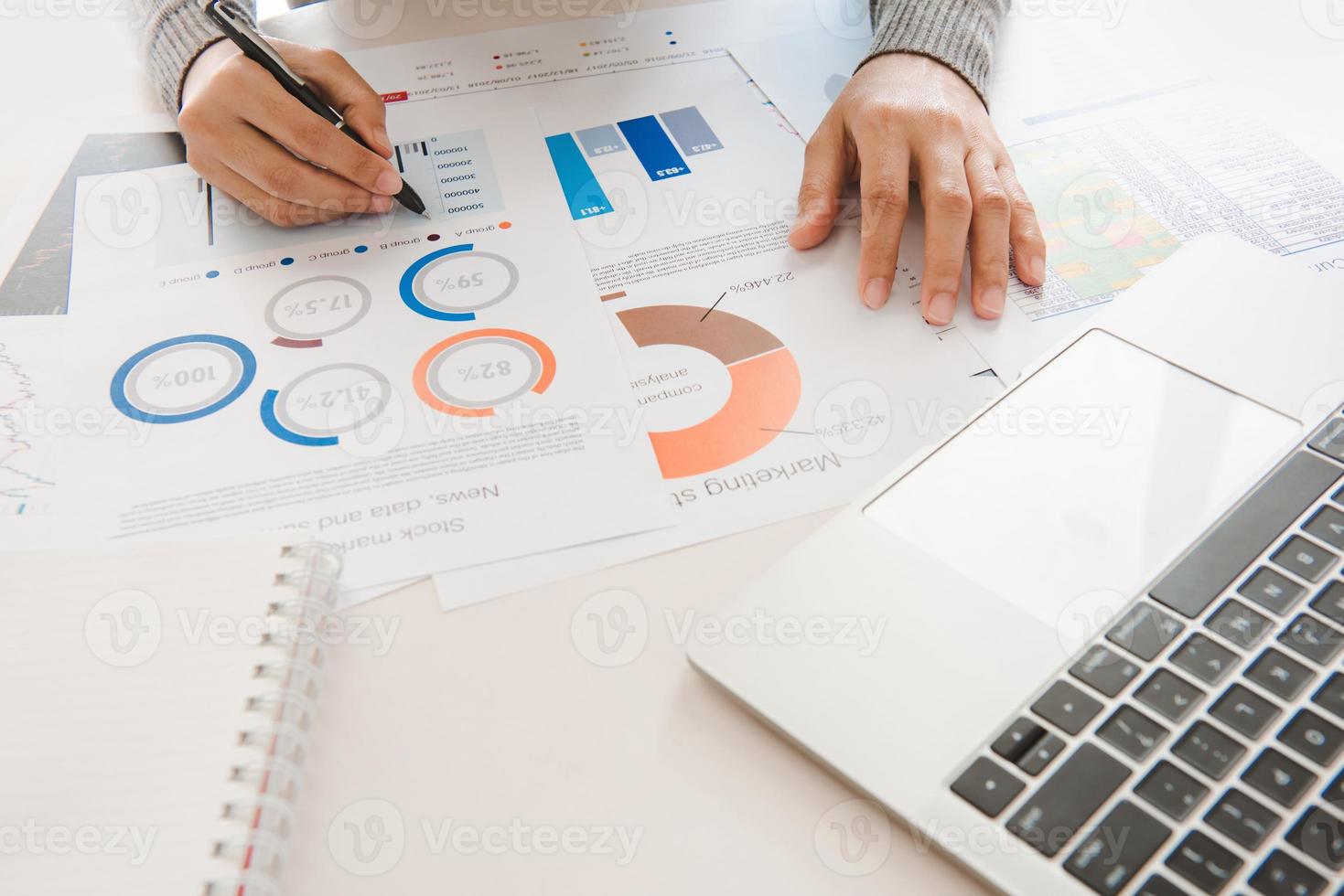 geschäftsfrau analysiert dokument in seinen händen. grafiken und diagramm auf notebook-bildschirm. finanz- und investitionskonzept. foto