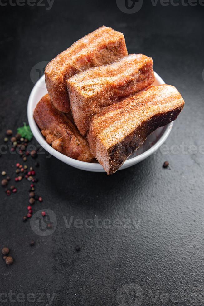 Bauchfleisch Speck Stück Fleisch Fett Schmalz frisches Schweinefleisch in Gewürzen frische Mahlzeit auf dem Tisch kopieren Raum Essen Hintergrund foto