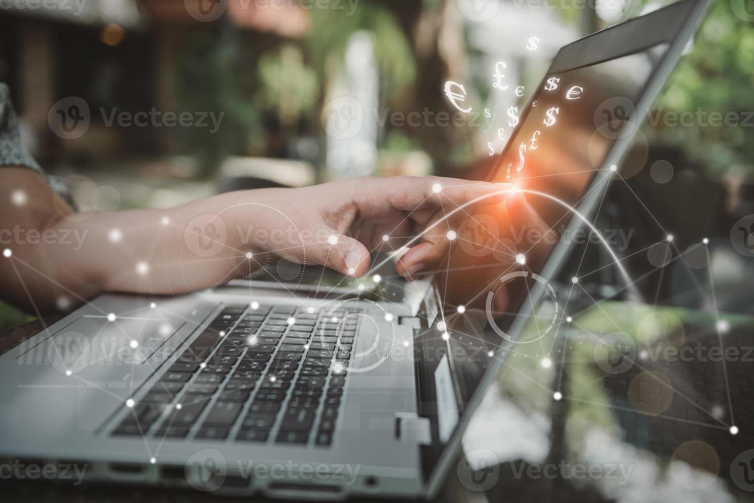 Geschäftsfrau zeigt mit dem Finger auf den Laptop-Monitor, während sie auf das Banking von Informationen zugreift, das mit dem virtuellen Bildschirm für den Geldwechsel verbunden ist. technologie internet netzwerkverbindung für unternehmen finanziell foto