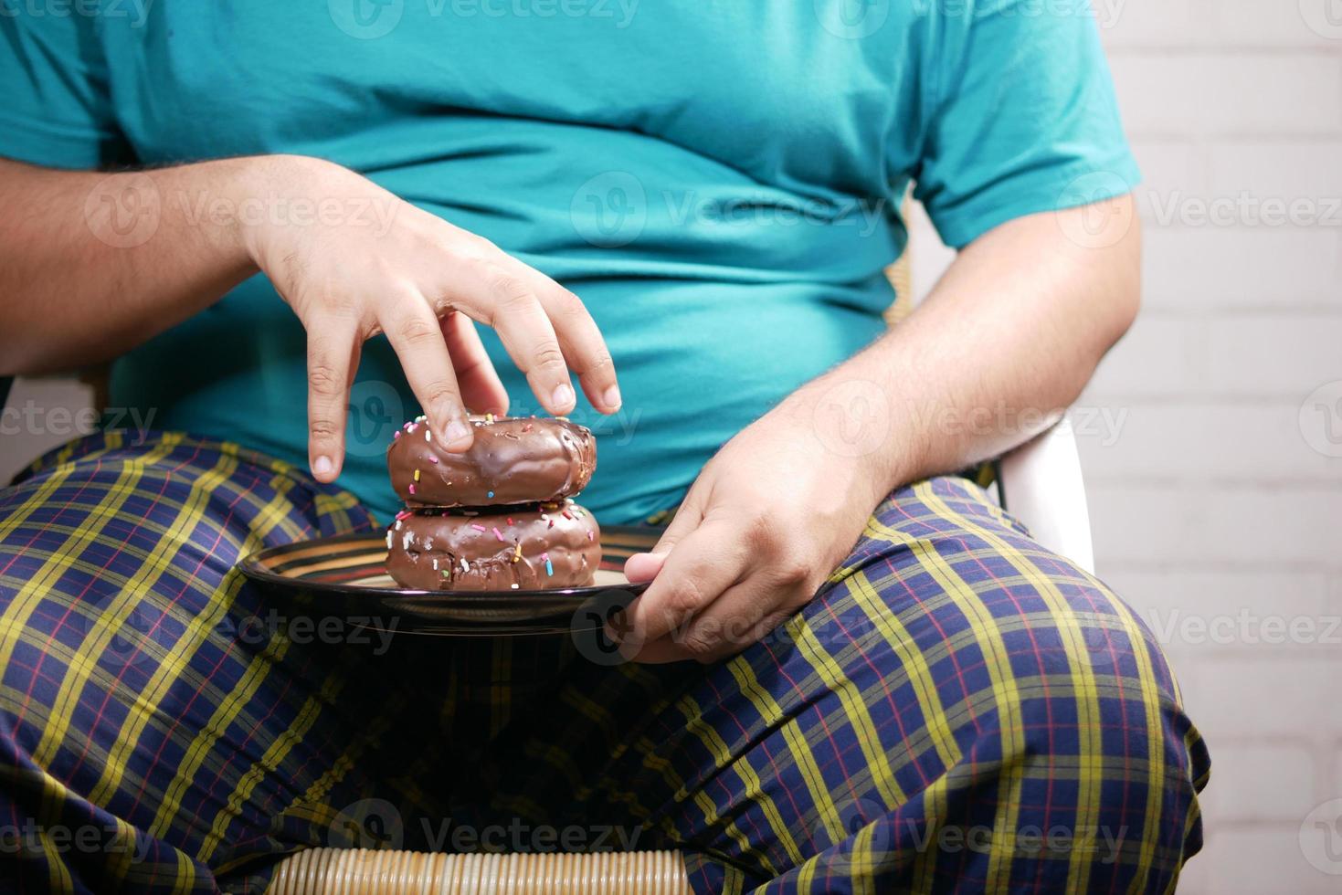 junger Mann isst Donut, selektiver Fokus foto