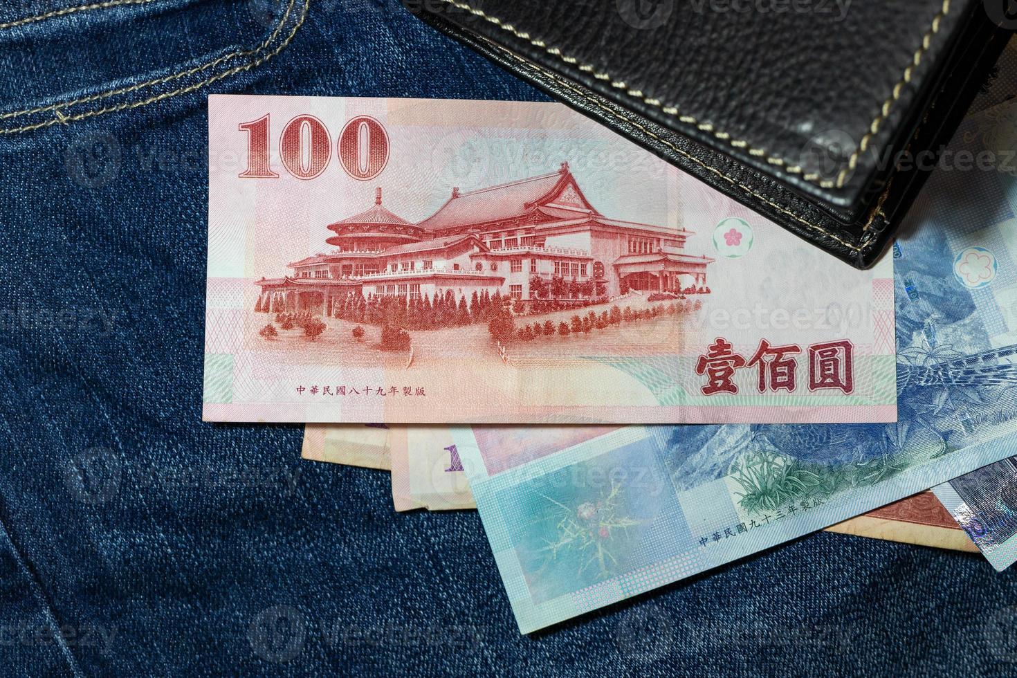 taiwanesisches Geld, taiwanesische Banknote, taiwanesischer Dollar auf Jeanshintergrund. foto