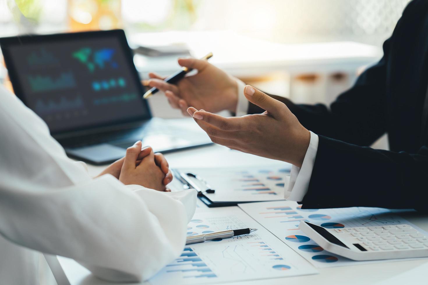 anwesendes geschäftsteamtreffen, investorenkollegen diskutieren neue planfinanzdiagrammdaten auf bürotisch mit laptop, finanzen, buchhaltung, investitionen. foto