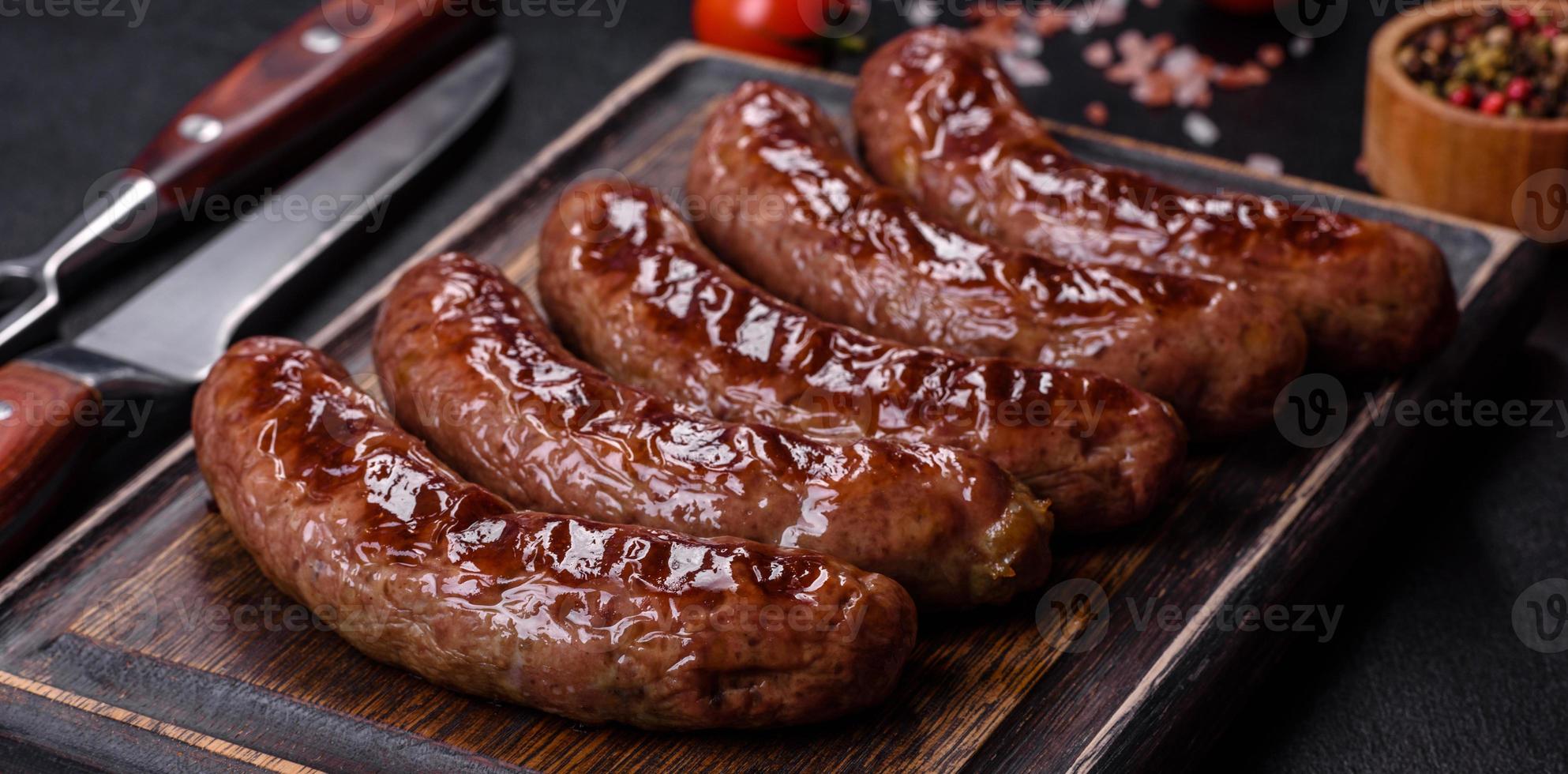 Grillwürste mit Zutaten auf einem Schneidebrett auf Steingrund foto