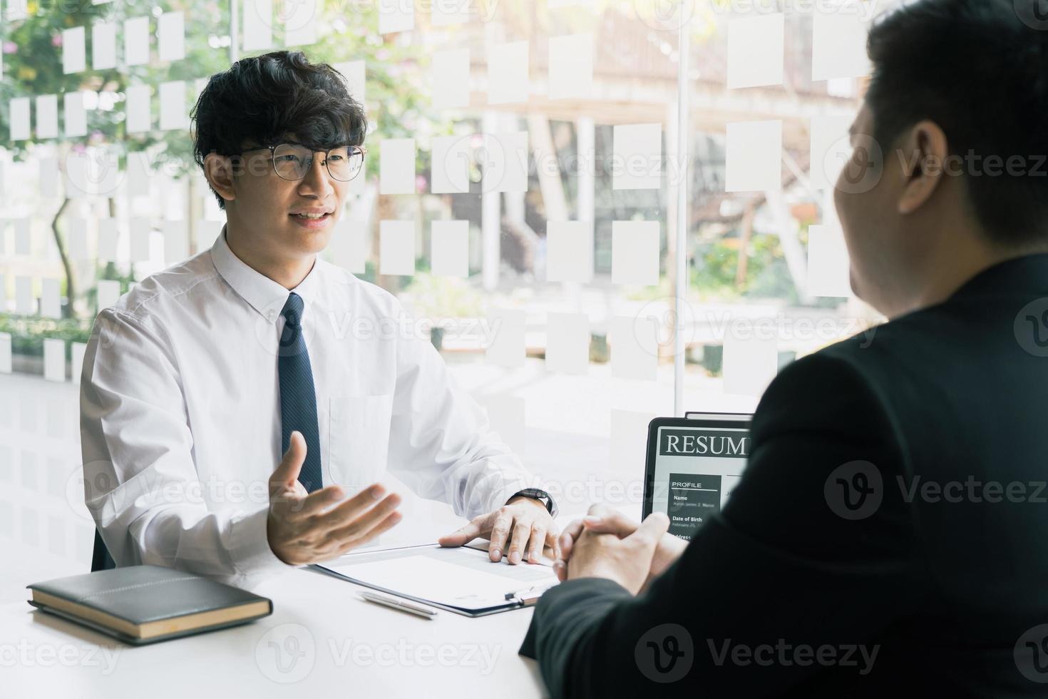 den Interviewraum, während die Mitarbeiter das Lebenslaufdokument vorbereiten und dem Manager präsentieren, der über die Arbeitserfahrung spricht und diese analysiert. foto