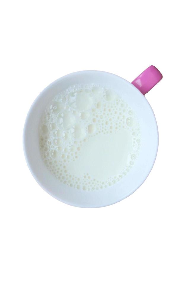 Becher Milch auf weißem Hintergrund foto