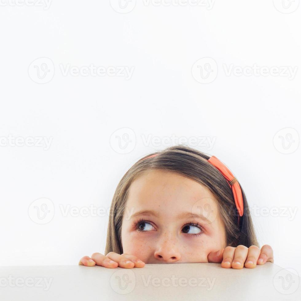 Mädchen schaut auf eine Tischkante foto
