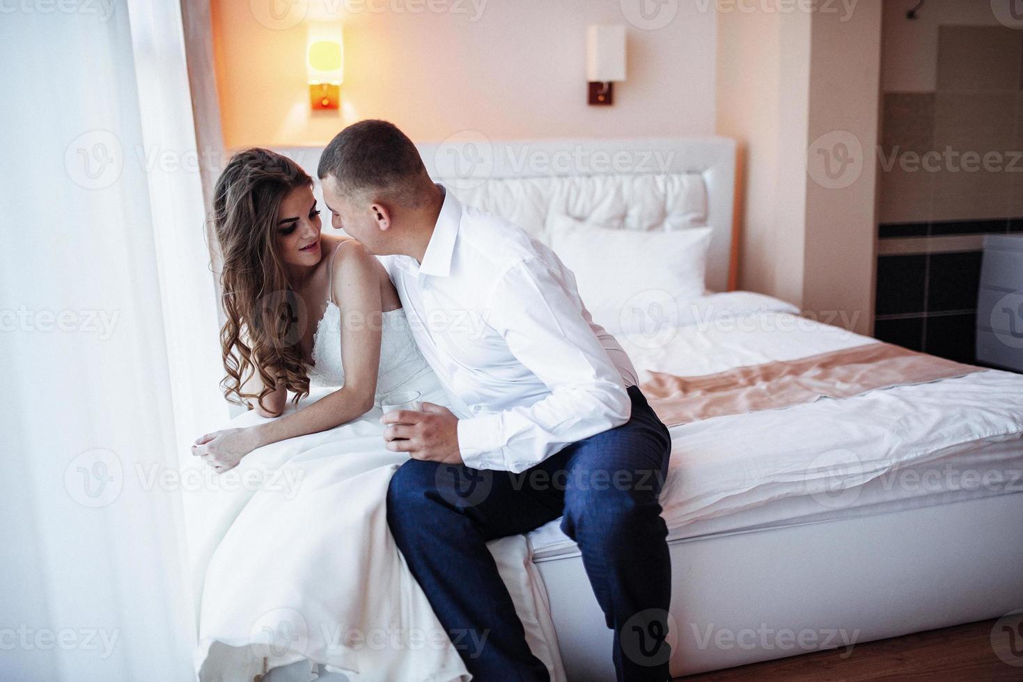 Braut sitzt auf dem Bett foto