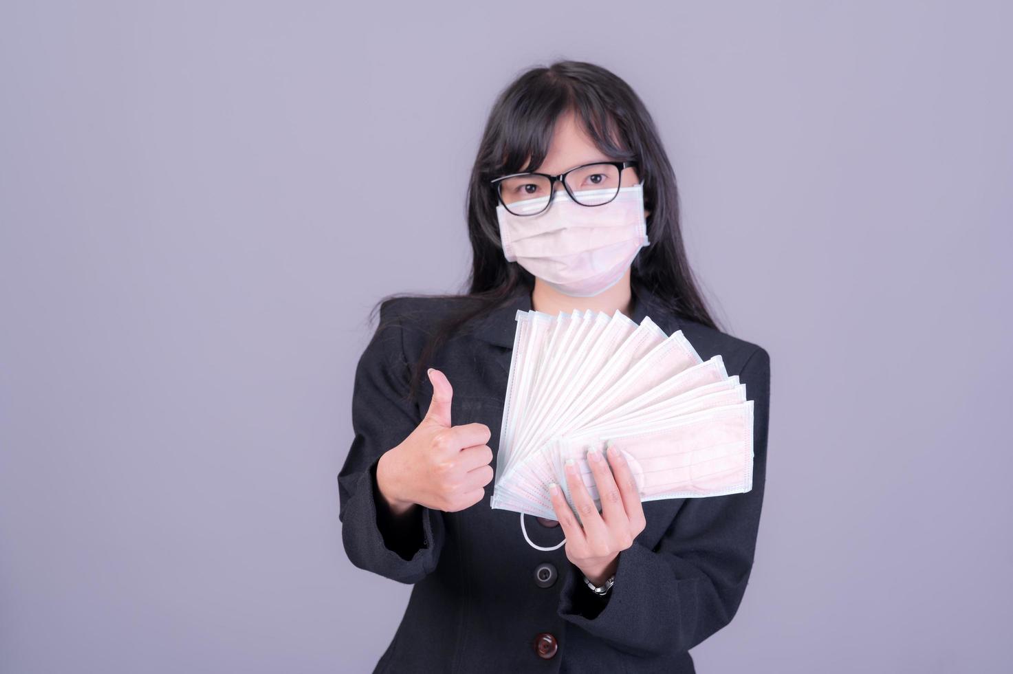 asiatische geschäftsfrauen müssen eine maske verwenden, um das gesicht zu bedecken, um eine verschmutzung durch staub zu vermeiden foto