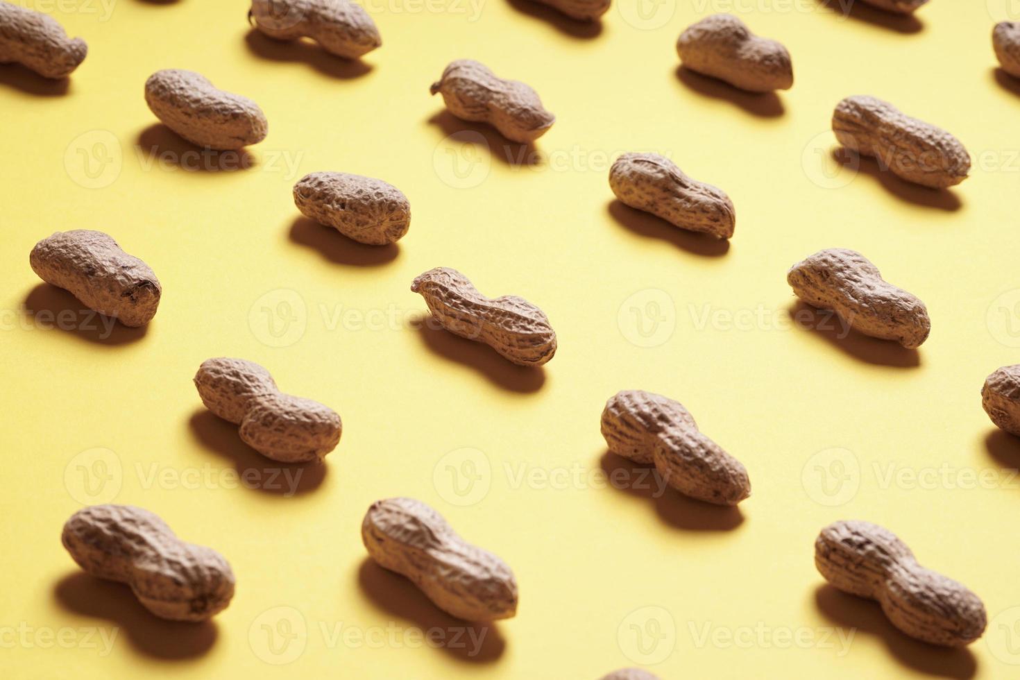 Erdnüsse in Reihen auf gelbem Hintergrund angeordnet foto