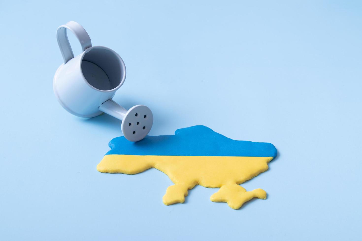 ukraine-kartenform in gelben und blauen farben der nationalflagge und einer sprinkleranlage. infusion, investition, spenden im ukraine-konzept foto