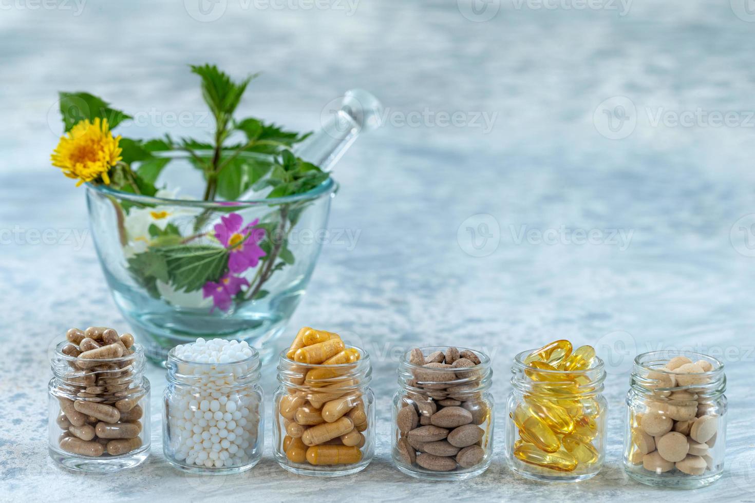 Flasche Pillen Nahrungsergänzungsmittel gesunde Medizin, Medikamente Gesundheitsbehandlung Zusatzstoffe Apotheke mit weißem Keramikmörser mit frischen Heilpflanzen im Hintergrund foto