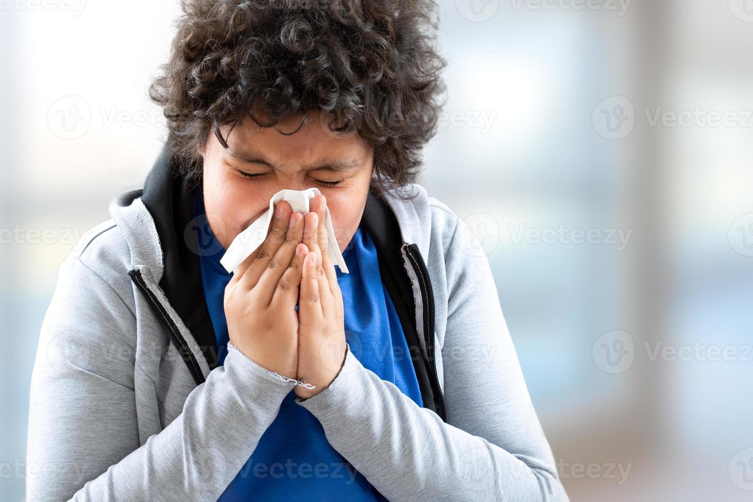 junge Teenager kalte Grippe Krankheit Gewebe bläst laufende Nase.- Kind bläst seine Nase. saisonaler Virus gefangen foto