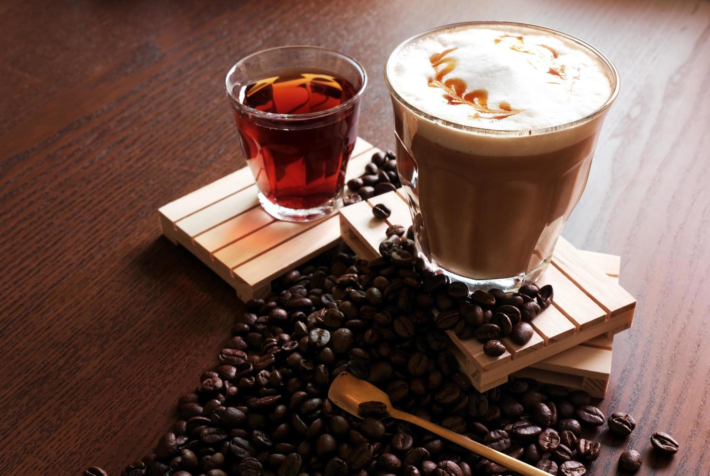 heißer kaffee und heißer tee, kaffeebohnen auf holztisch foto