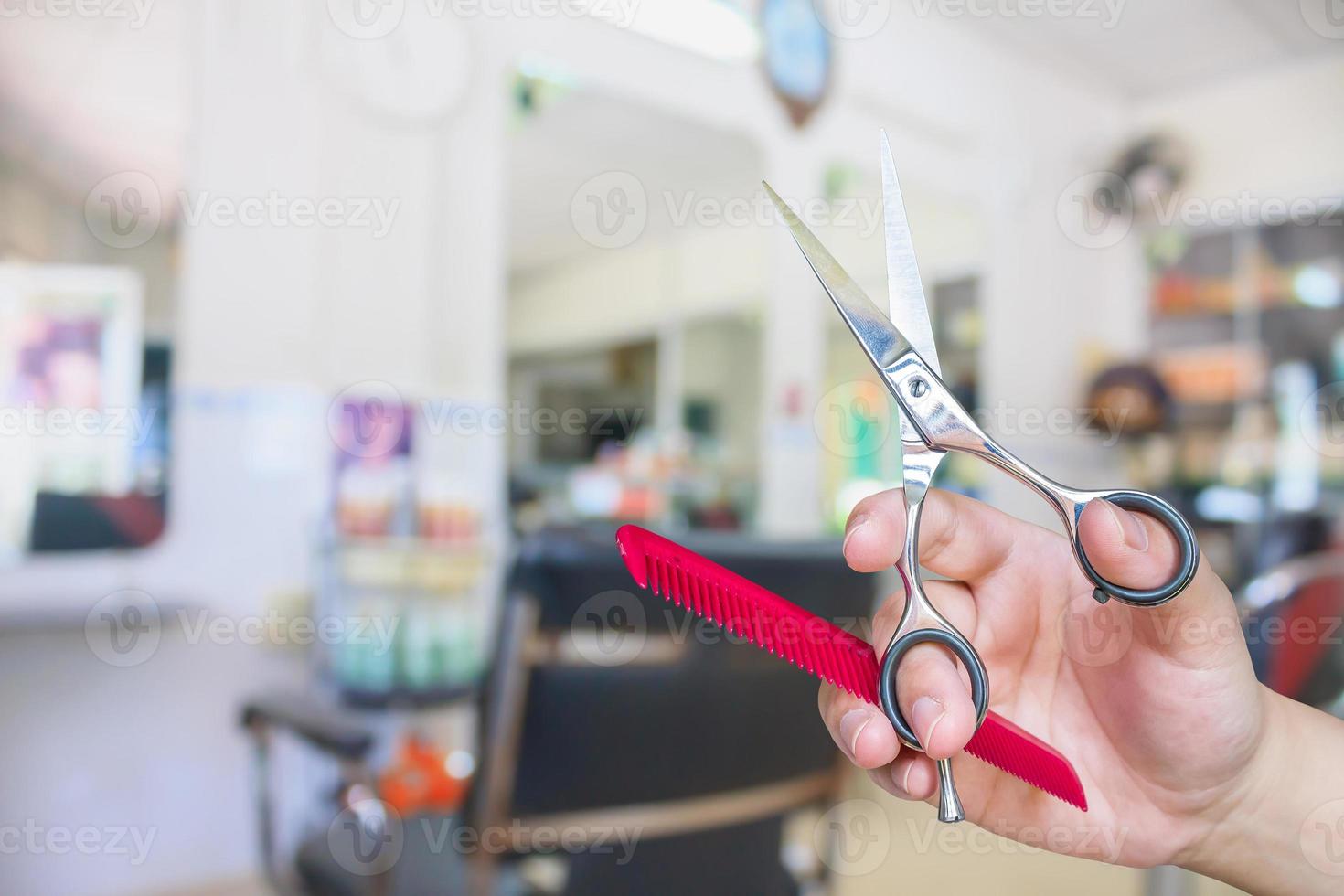 friseur hält schere mit salonschönheitshintergrund foto