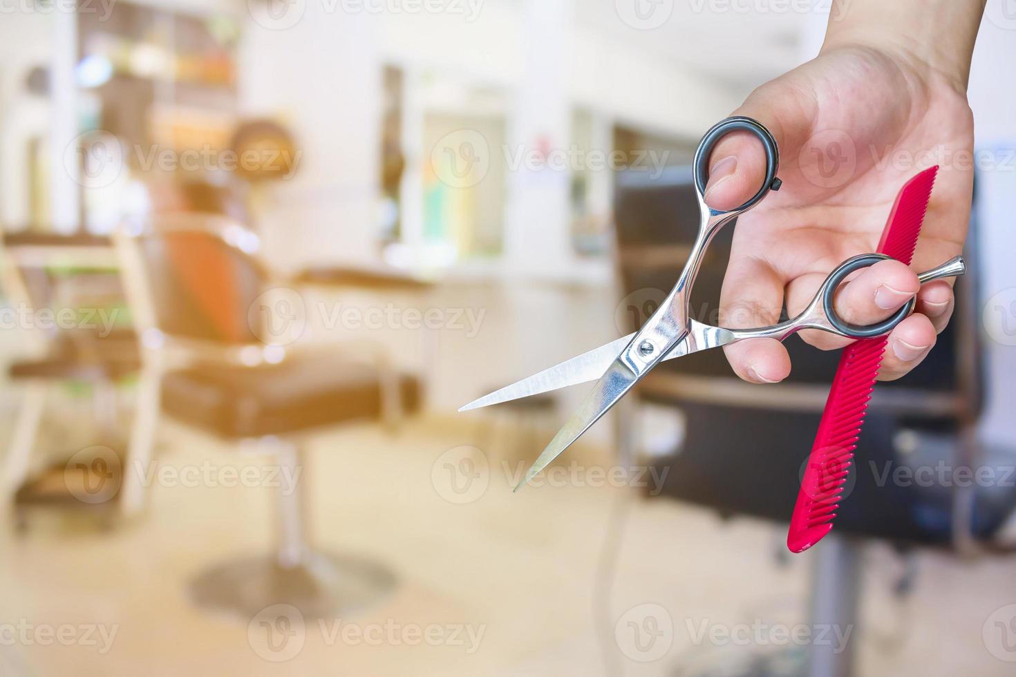 friseur hält schere mit salonschönheitshintergrund foto