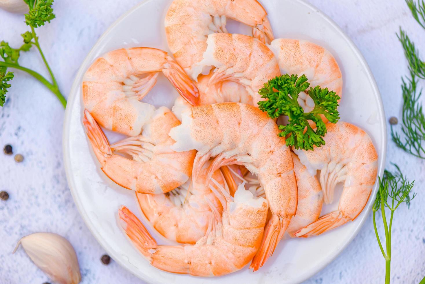 frische Garnelen, serviert auf weißem Teller, gekochte, geschälte Garnelen, die im Fischrestaurant zubereitet werden foto