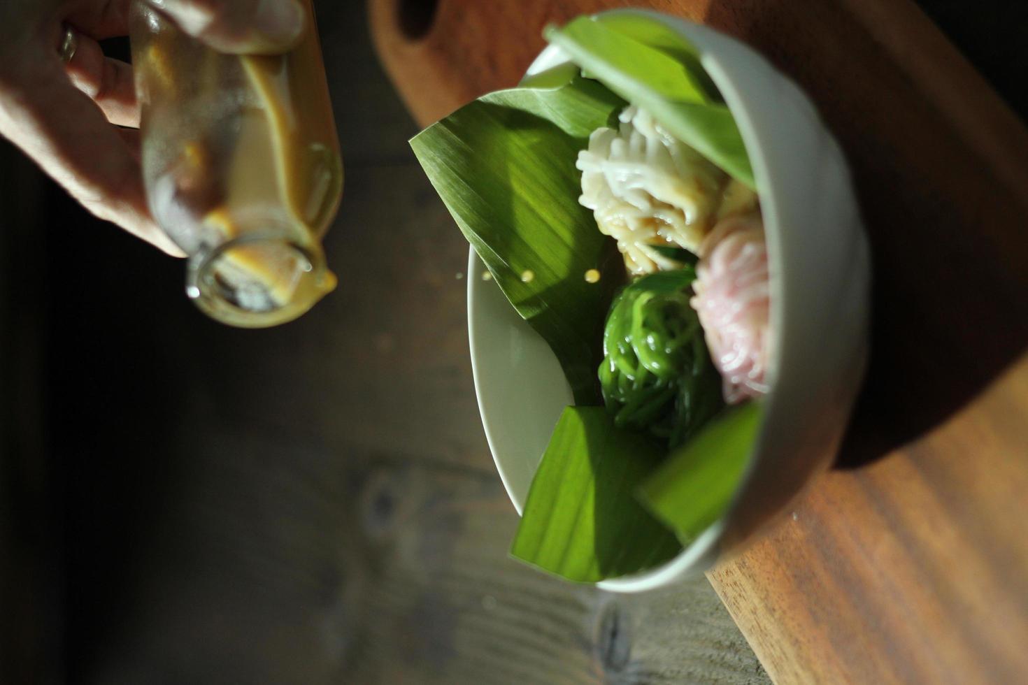 Blick aus der Vogelperspektive auf das indonesische Betawi-String-Hopper-Gericht namens Putu Mayang-Kuchen mit nudelartiger Form, serviert mit flüssigem Palmzucker. foto