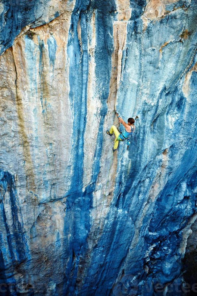 Kletterer klettert eine Klippe hinauf foto