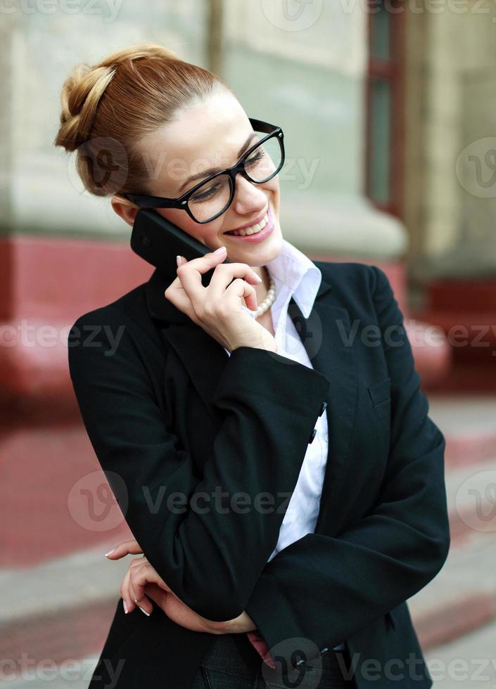 lächelnde Geschäftsfrau, die auf Handy spricht foto