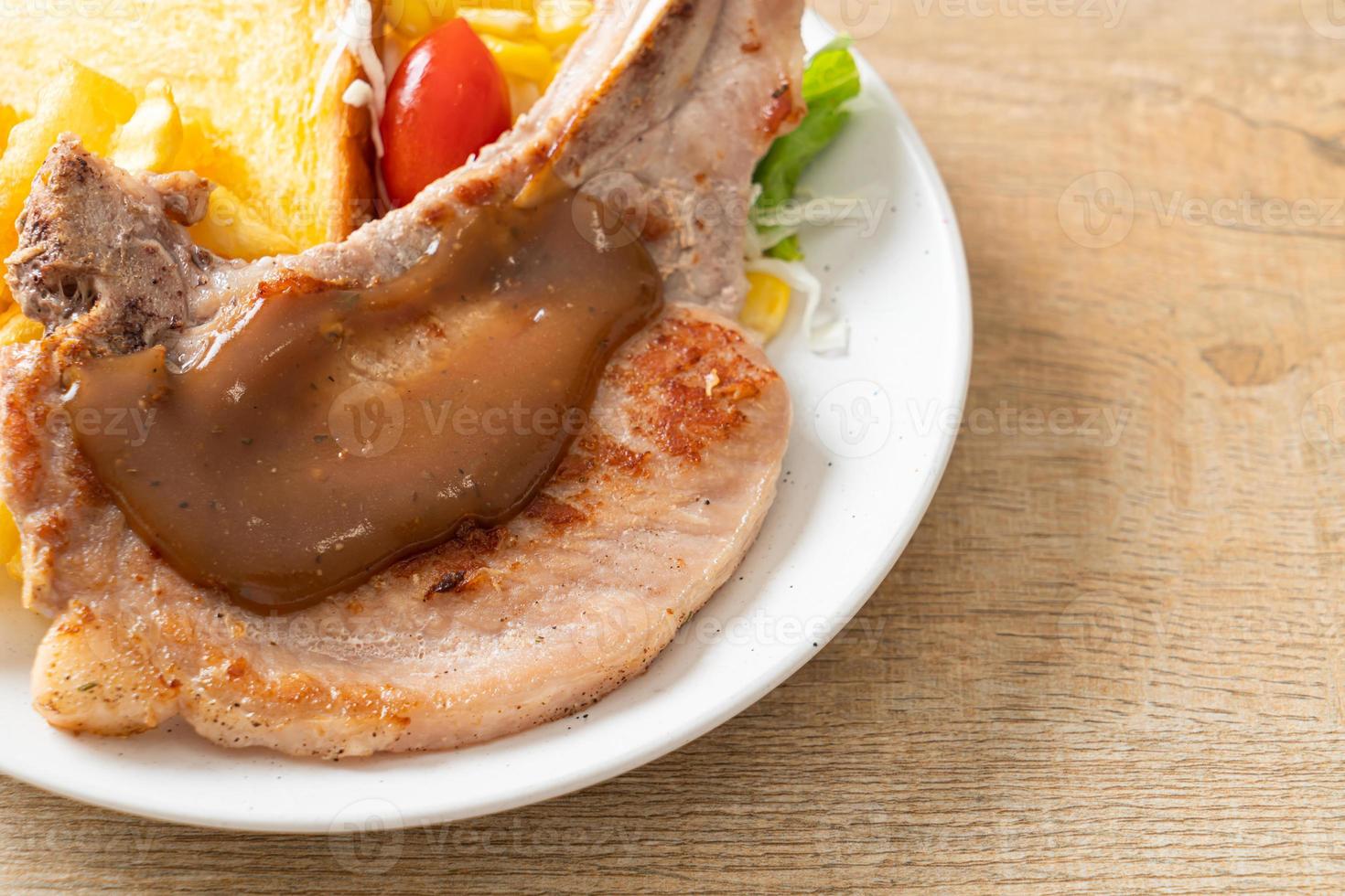 Schweinekotelettsteak mit Pommes und Minisalat foto