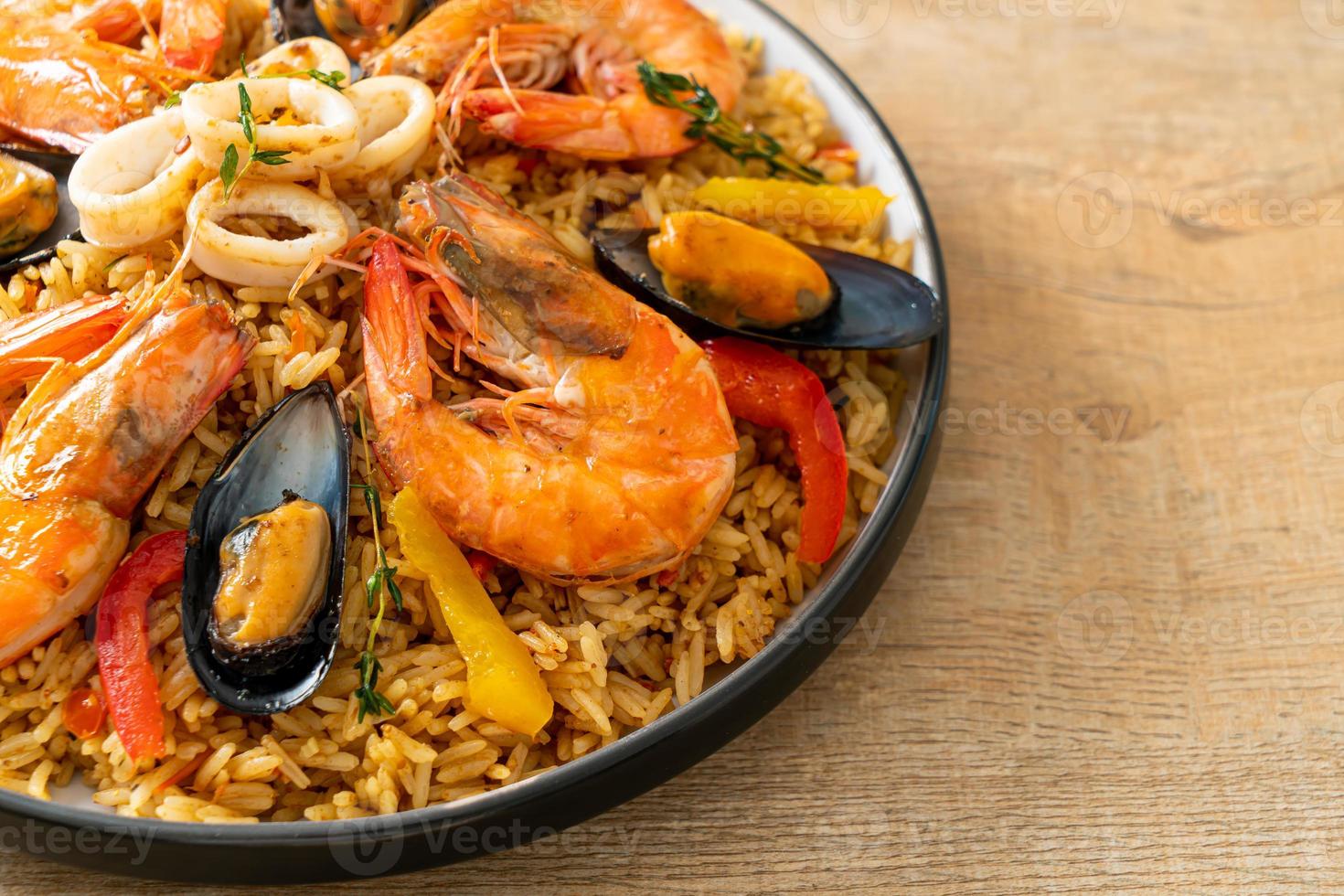 Meeresfrüchte-Paella mit Garnelen, Venusmuscheln, Miesmuscheln auf Safranreis foto