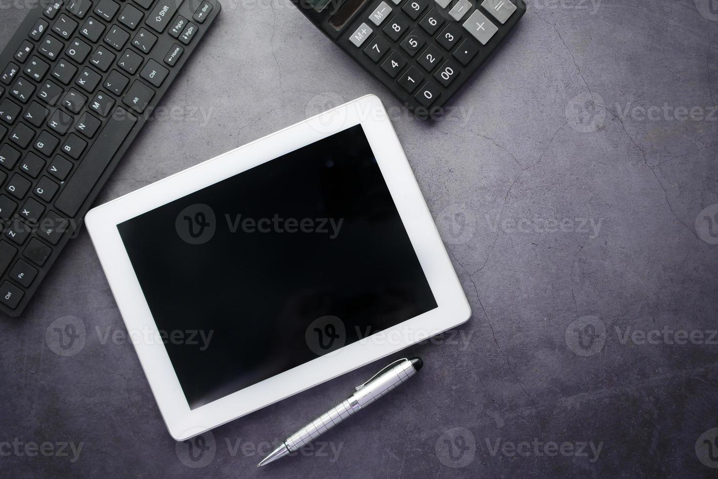 flache Zusammensetzung des digitalen Tabletts und des stationären Büros auf schwarzem Hintergrund foto