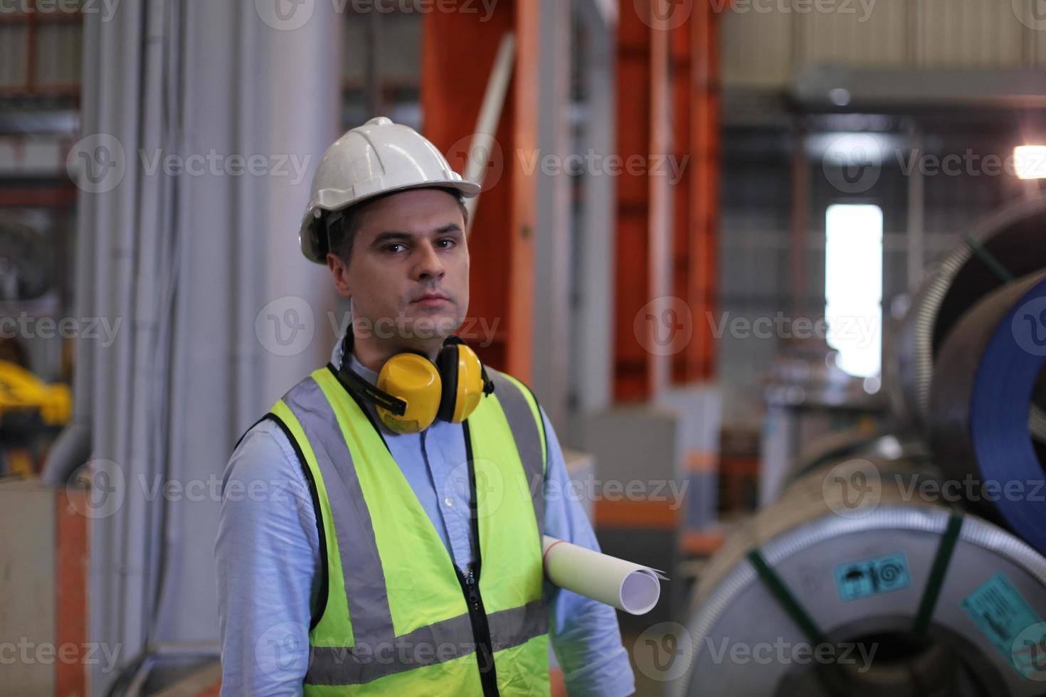 Männer-Wirtschaftsingenieur, der einen Schutzhelm trägt, während er in einer Schwerindustriefabrik steht. die Wartung von Arbeiten an Industriemaschinen und die Einrichtung des Sicherheitssystems in der Fabrik. foto