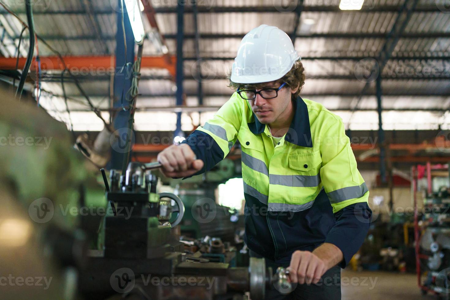 wirtschaftsingenieur oder arbeiter, der einen helm trägt, während er in einer schwerindustriefabrik steht. die Wartung von Arbeiten an Industriemaschinen und die Einrichtung des Sicherheitssystems in der Fabrik. foto