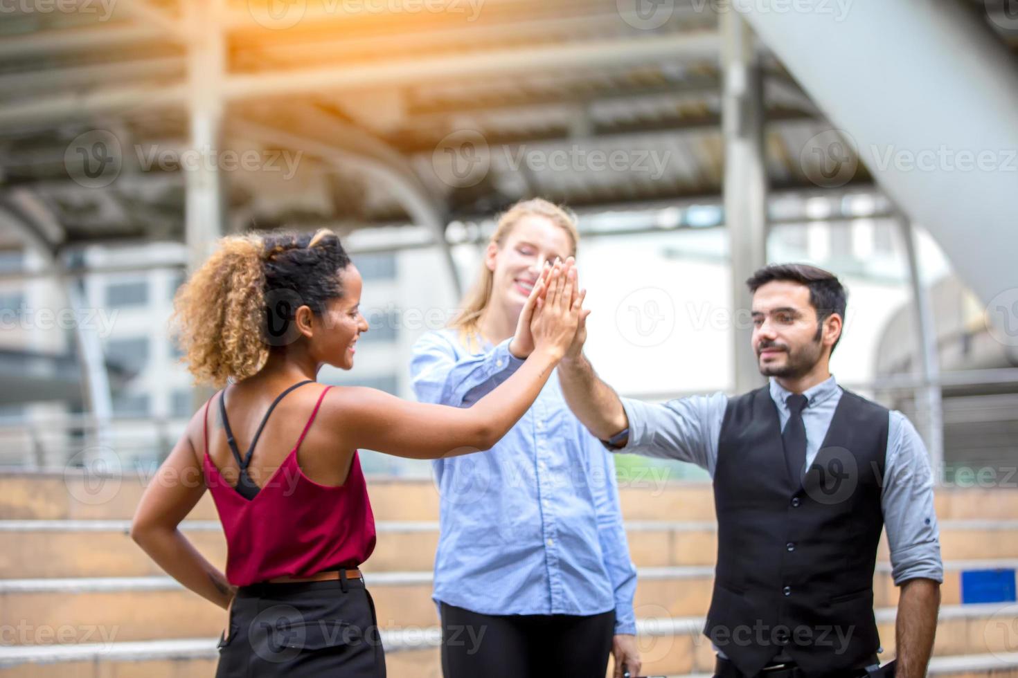 erfolgreiche geschäftsleute, die zusammenstehen, erweitern sich und zeigen eine starke beziehung der arbeitnehmergemeinschaft. ein team von geschäftsleuten und geschäftsfrauen, die eine starke gruppenteamarbeit im modernen büro zum ausdruck bringen. foto