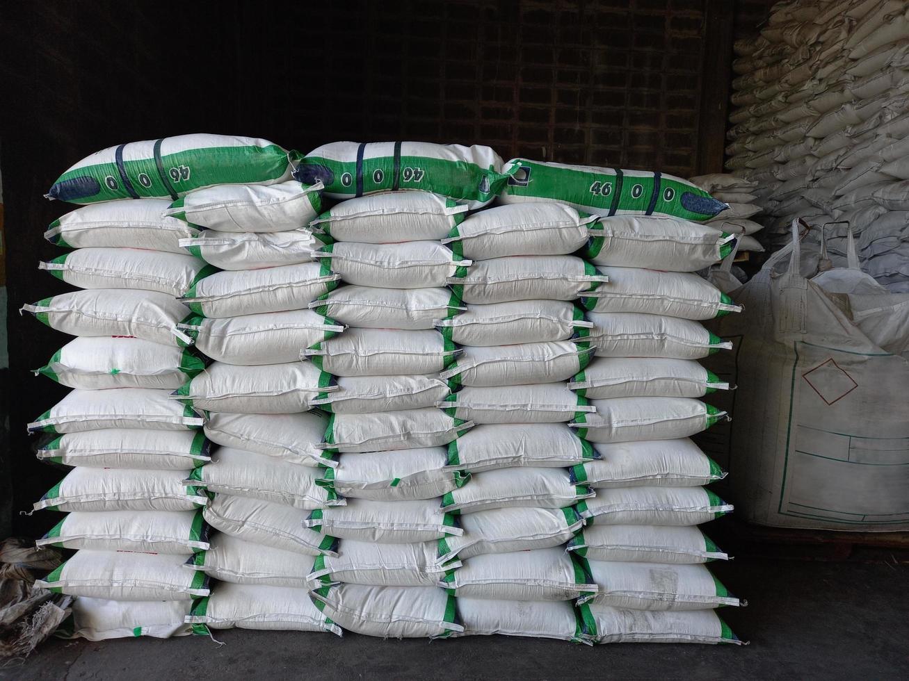 Großer Jumbo-Hanfsack weiß, verpackt mit chemischem Dünger, Reis, Zucker, auf einer Holzpalette platziert, die darauf wartet, an den Kunden geliefert zu werden foto