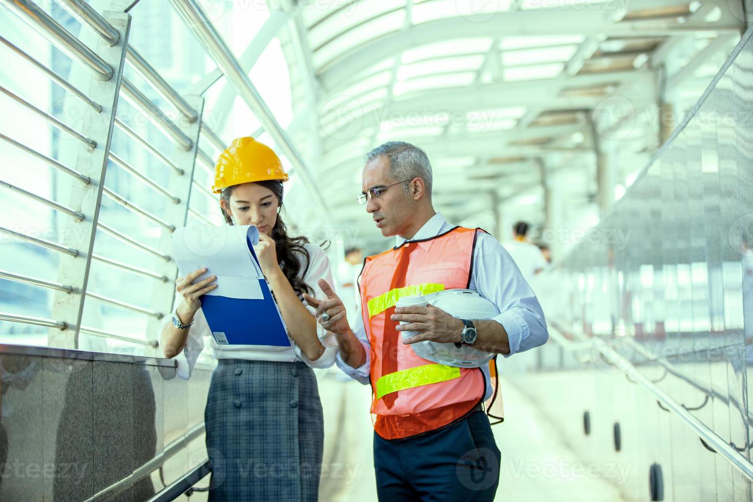 Der Ingenieur und die Geschäftsfrau überprüfen die Zwischenablage im Baustellengebäude. das konzept von engineering, bau, stadtleben und zukunft. foto