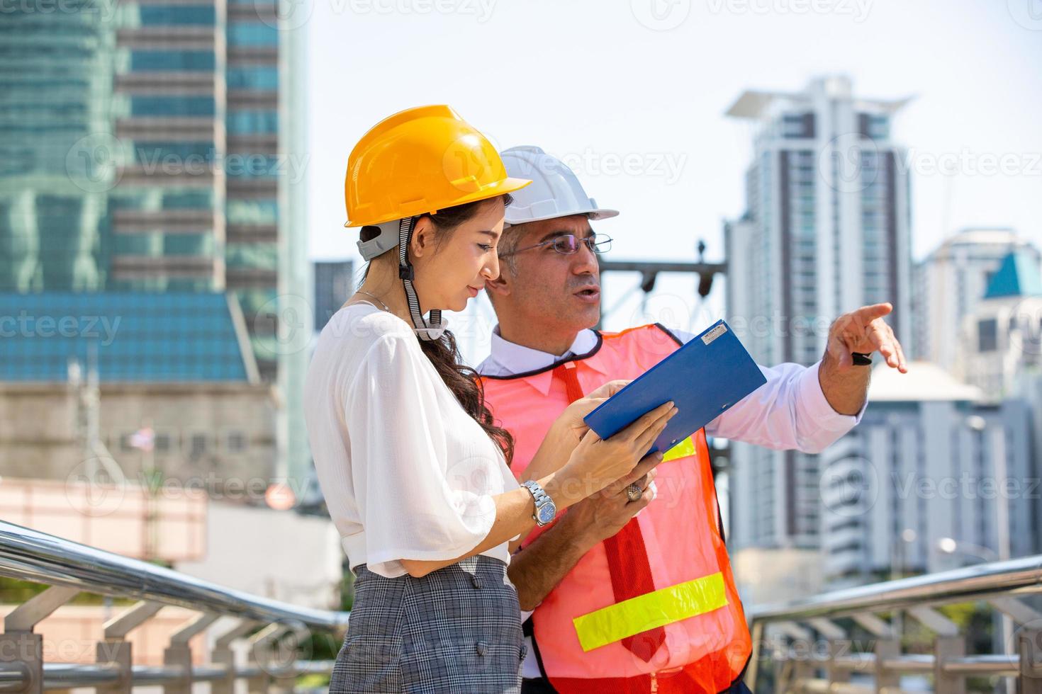 Der Ingenieur und die Geschäftsfrau überprüfen die Zwischenablage im Baustellengebäude. das konzept von engineering, bau, stadtleben und zukunft. foto