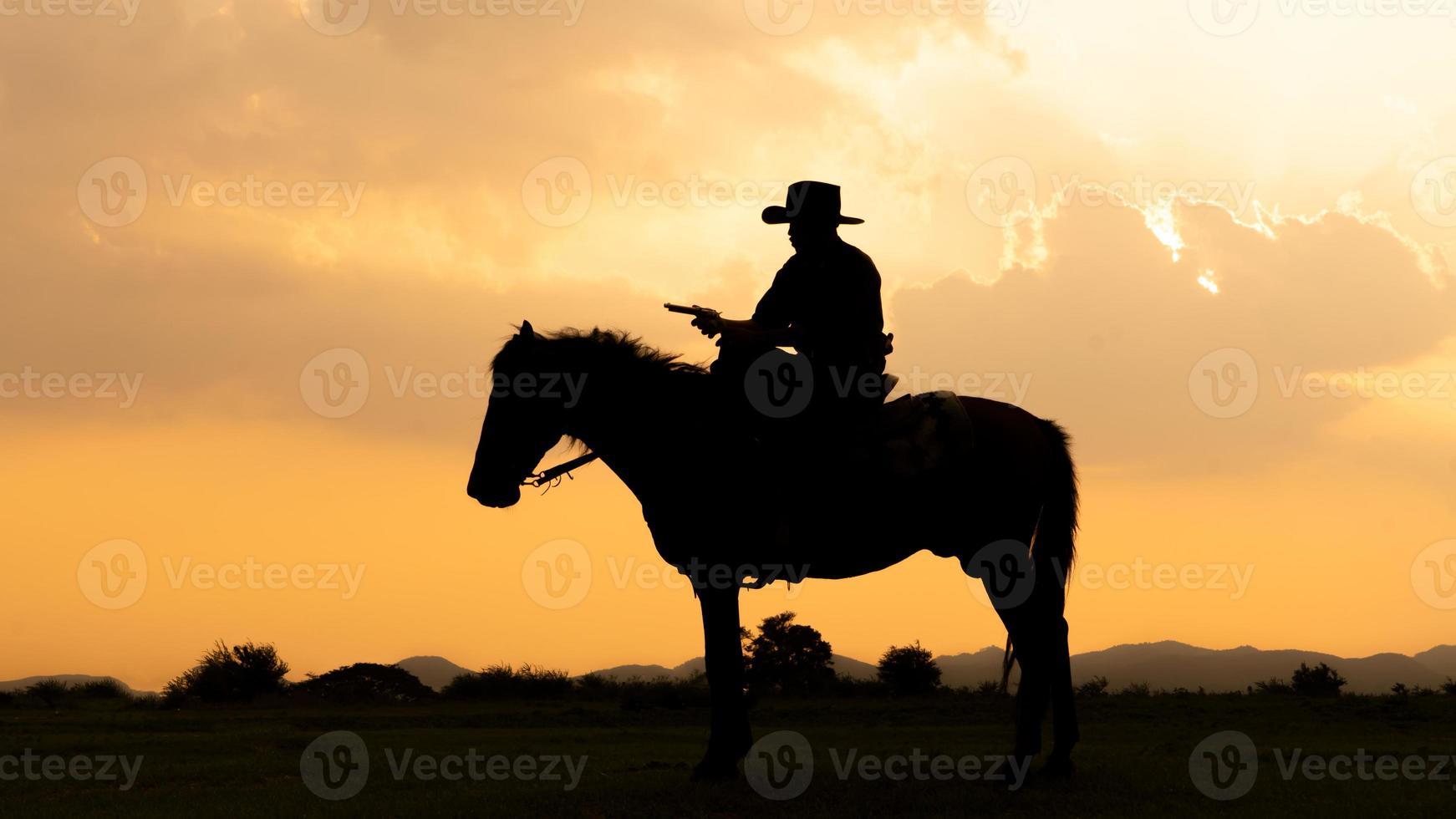 Silhouette Cowboy zu Pferd vor einem wunderschönen Sonnenuntergang, Cowboy und Pferd im ersten Licht, Berg, Fluss und Lebensstil mit natürlichem Lichthintergrund foto