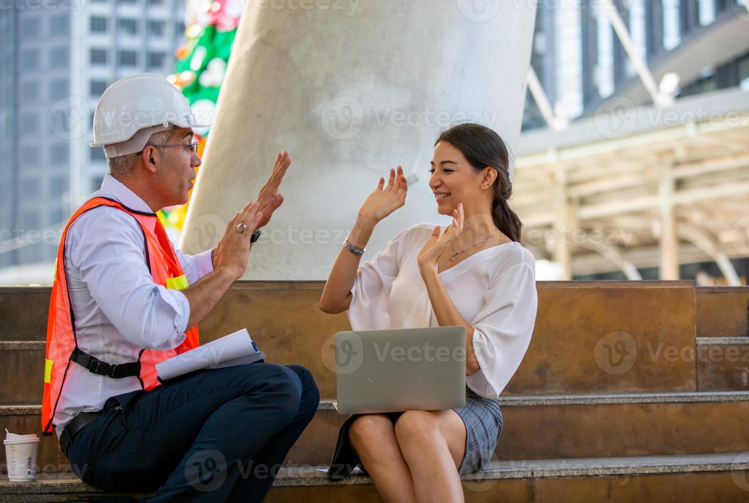 der ingenieur und die kaufleute geben high five gegen den bau. das konzept von engineering, bau, stadtleben und zukunft. foto