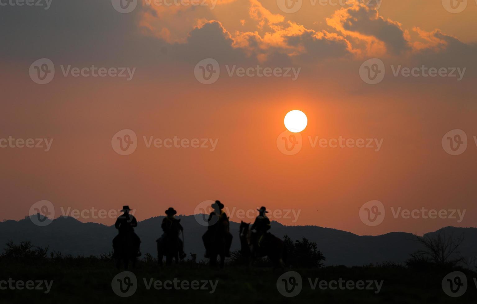 Silhouette Cowboy zu Pferd vor einem wunderschönen Sonnenuntergang, Cowboy und Pferd im ersten Licht, Berg, Fluss und Lebensstil mit natürlichem Lichthintergrund foto