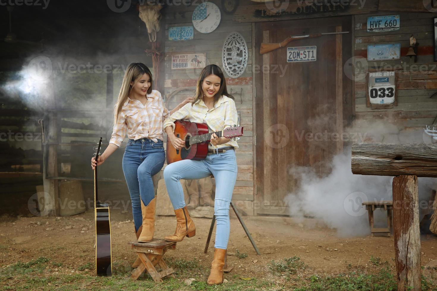 Cowgirl-Model posiert auf dem Bauernhof. ein Porträt eines schönen jungen Cowgirls, das sich in einem Stall auf einer Farm an eine Wand lehnt. foto