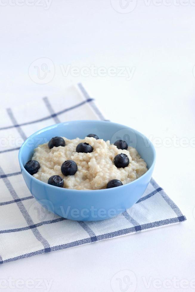 haferbrei mit blaubeeren in einem blauen teller auf einer karierten serviette. Food-Fotografie foto