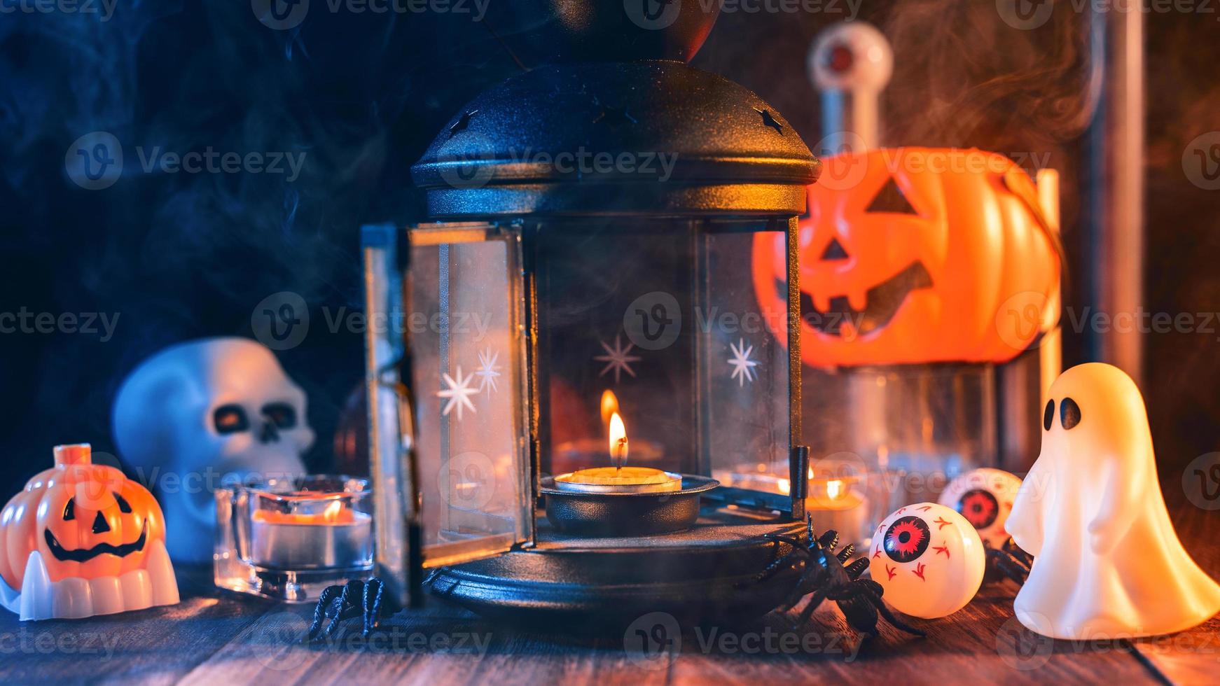 halloween-feiertagskonzeptdesign von kürbis, kerze, gruseligen dekorationen mit grüntonrauch herum auf einem dunklen holztisch, nahaufnahme. foto