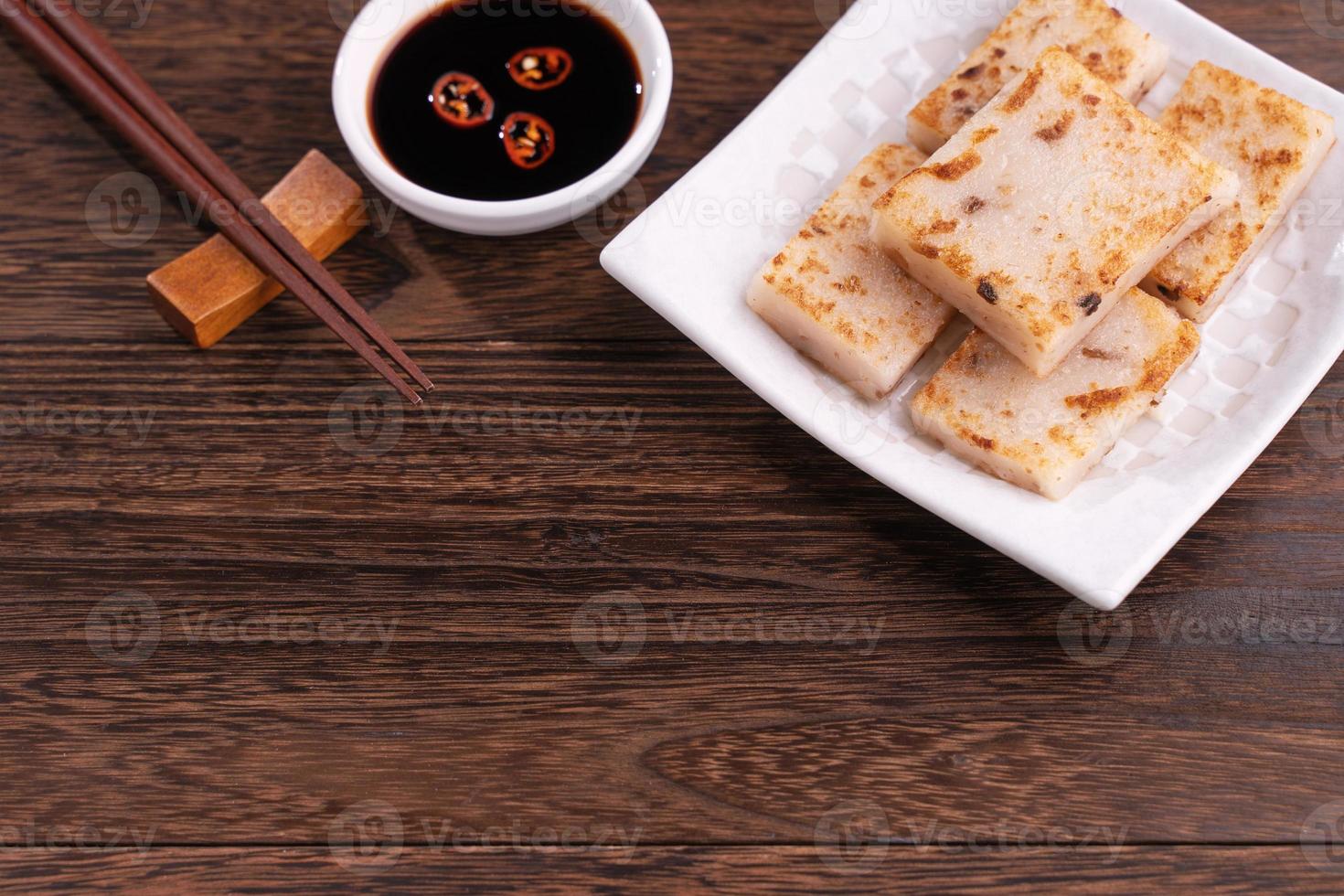 Köstlicher Rübenkuchen, traditioneller chinesischer Rettichkuchen im Restaurant mit Sojasauce und Essstäbchen, Nahaufnahme, Kopierraum. foto