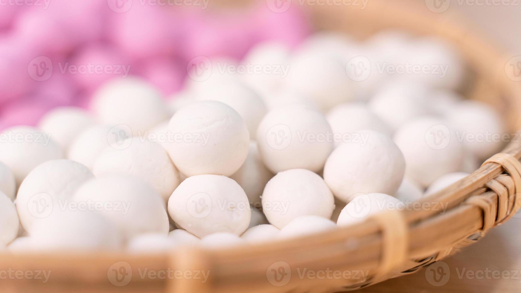 Eine asiatische Frau macht Tang Yuan, Yuan Xiao, traditionelle chinesische Reisknödel in Rot und Weiß für das neue Mondjahr, Winterfest, Nahaufnahme. foto